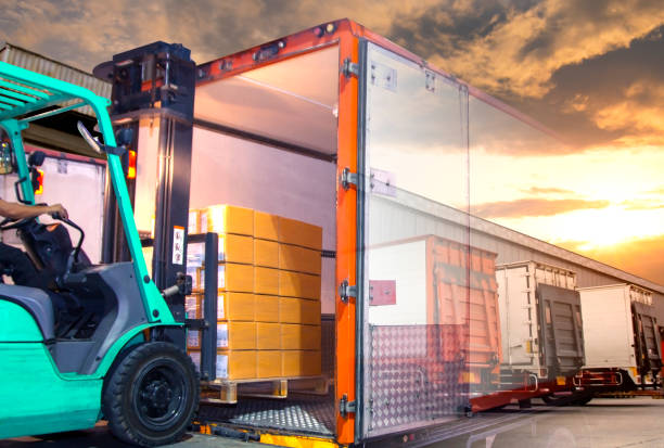 istock Double exposure of forklift loading shipment goods pallet into a truck container 1198942028