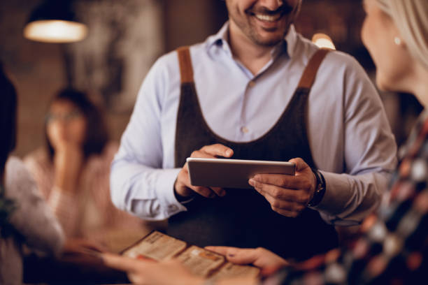 istock Unrecognizable waiter taking order on touchpad in a pub. 1198944291