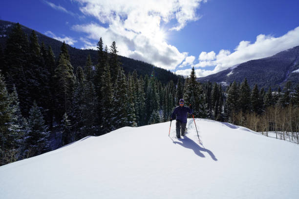 istock Man Snowshoeing in Scenic Mountain Environment 1198951298