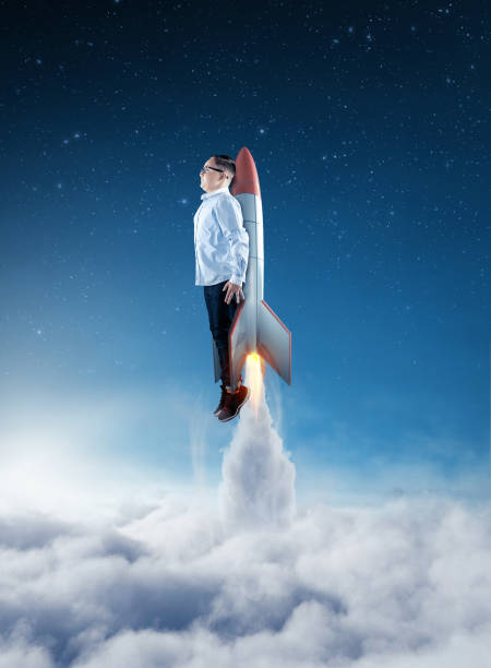 istock Young businessman flying above clouds with a rocket. Launch start up business concept. 1198952765