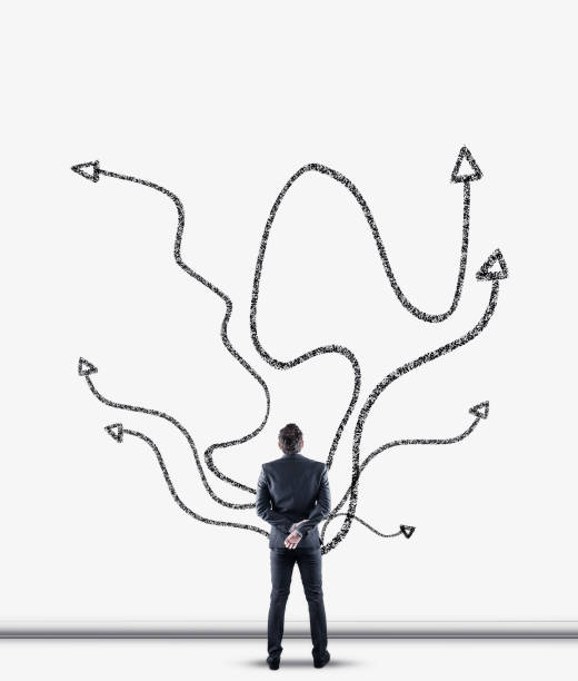 businessman standing in front of  a wall drawn with different arrows. - investment variation development growth imagens e fotografias de stock