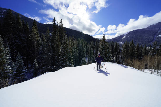 istock Man Snowshoeing in Scenic Mountain Environment 1198952854