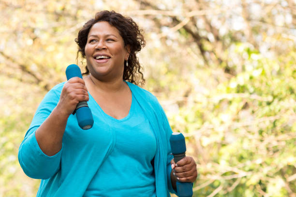 Mature African American woman smiling and exercising. Mature African American woman walking. overweight stock pictures, royalty-free photos & images