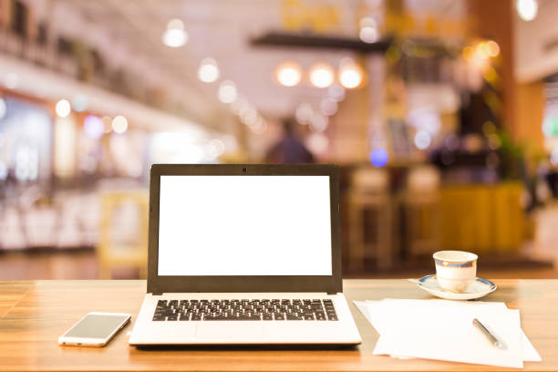 immagine mockup del laptop con schermo bianco vuoto su un tavolo di legno immagini sfocate nella caffetteria sullo sfondo del centro commerciale. - computer key internet cafe coffee internet foto e immagini stock