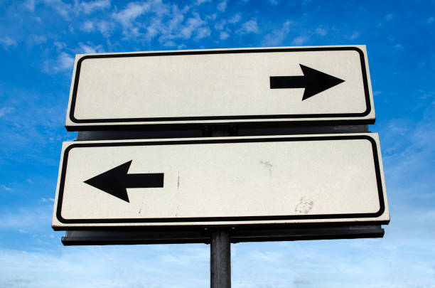 十字路道路標識、青空背景の2つの矢印 - copy space left ストックフォトと画像