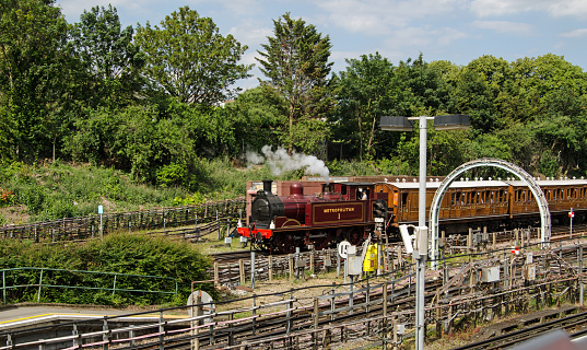 London, UK - June 22, 2019:  The historic Metropolitan 1 steam engine - the last steam train to use the District Line of London Underground marking 150th anniversary of the line.  Sunny Summer day, Ealing Broadway.