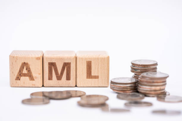Money laundering concept, wooden word block "AML" on plie of coins. stock photo