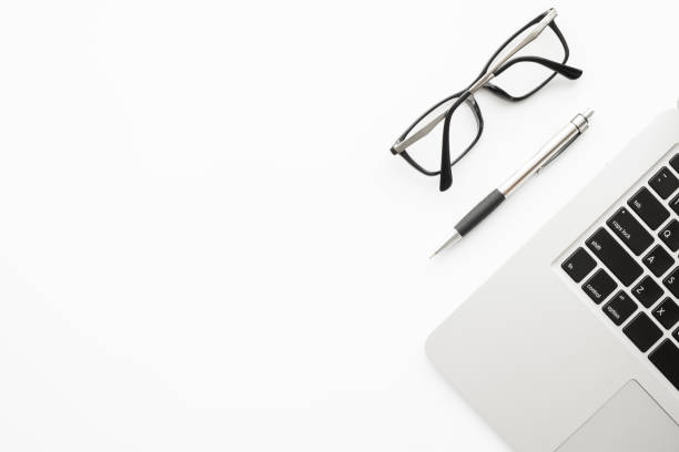 istock White office desk table with laptop computer, pen and eye glasses. Top view with copy space, flat lay. 1198960893