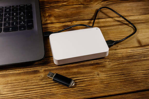 istock External HDD connected to laptop computer and USB flash drive on a wooden desk. Concept of data storage 1198961865
