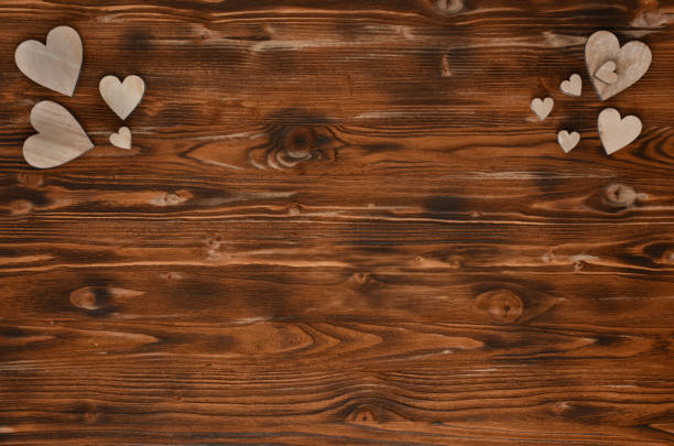 istock Handmade wooden hearts on a textured wood background. 1198963616