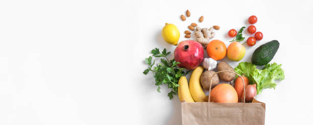 Organic vegan food Healthy food background. Healthy vegan vegetarian food in paper bag vegetables and fruits on white, copy space, banner. Shopping food supermarket and clean vegan eating concept. freshness stock pictures, royalty-free photos & images