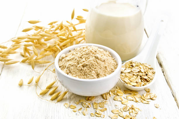istock Flour oat in bowl with milk on white board 1198966498