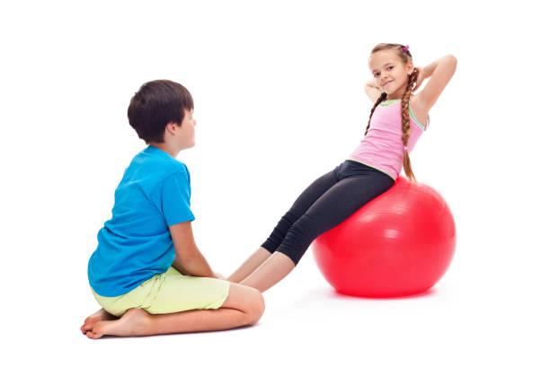 istock Kids exercising together using a large gymnastic rubber ball 1198968208