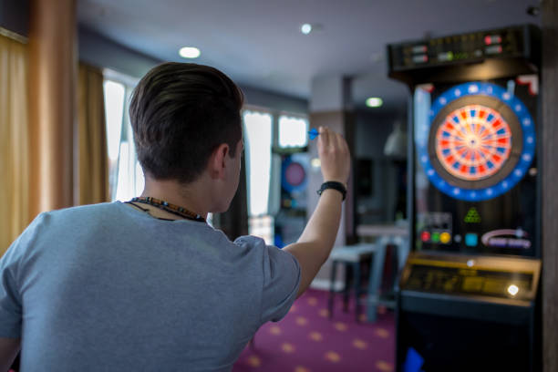 istock man playing a game of darts, focus on target 1198968489