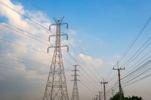 istock Large and small high-voltage electricity poles on the sky background 1198972840