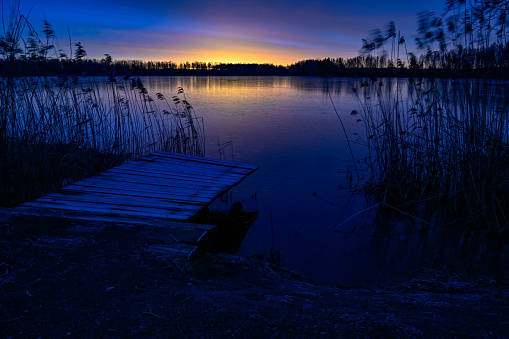sunrise over wooden jetty and frozen lake in Kumla Sweden 11 januari 2020