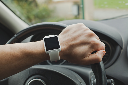 smart watch on the hand of car driver, close up