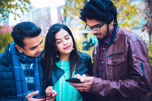 istock Group of University Students using smartphone to check the social media posts 1198973905