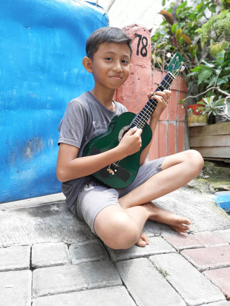 istock A Young Indonesian Boy Plays His Mandolin. 1198979226