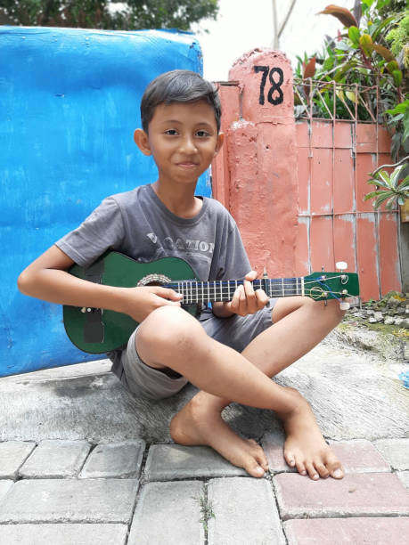 istock A Young Indonesian Boy Plays His Mandolin. 1198979731