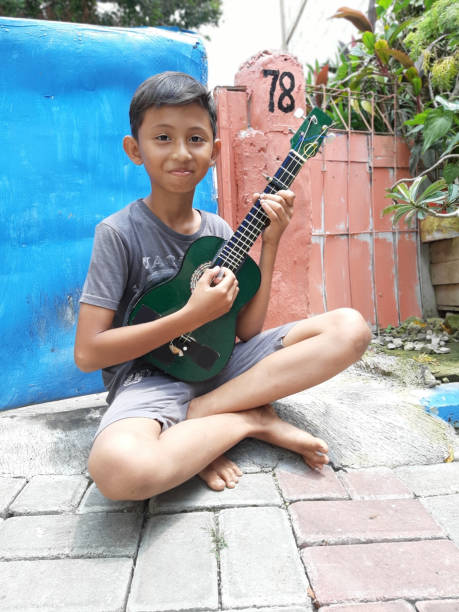 istock A Young Indonesian Boy Plays His Mandolin. 1198979733