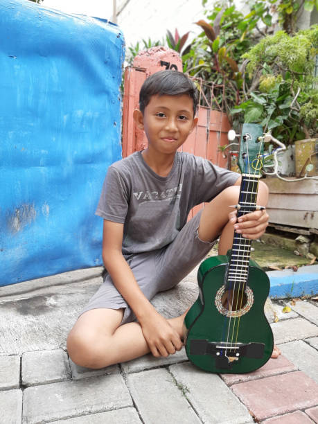 istock A Young Indonesian Boy Plays His Mandolin. 1198979745
