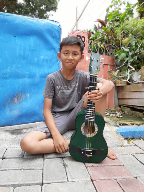 istock A Young Indonesian Boy Plays His Mandolin. 1198979748