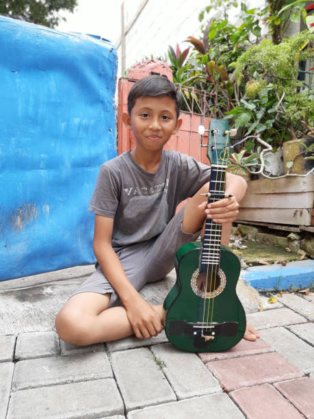 istock A Young Indonesian Boy Plays His Mandolin. 1198979751