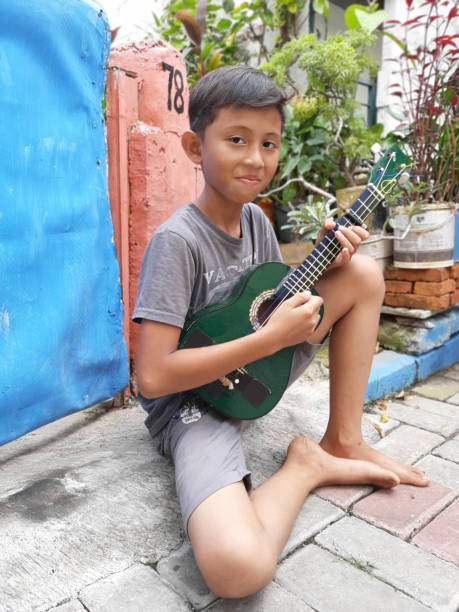 istock A Young Indonesian Boy Plays His Mandolin. 1198979756