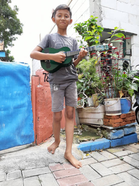 istock A Young Indonesian Boy Plays His Mandolin. 1198979763