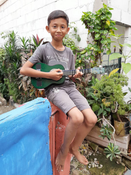 istock A Young Indonesian Boy Plays His Mandolin. 1198979836