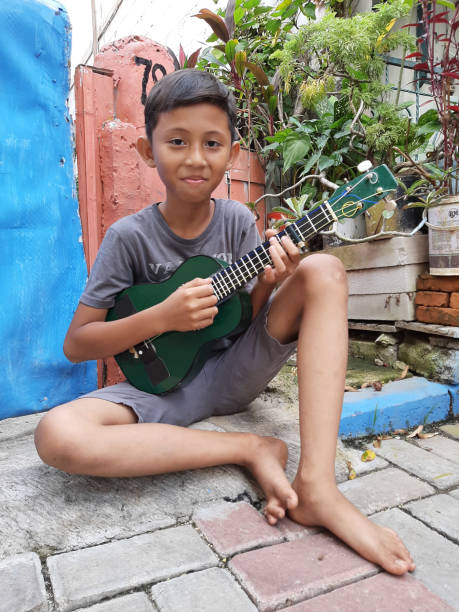 istock A Young Indonesian Boy Plays His Mandolin. 1198979857
