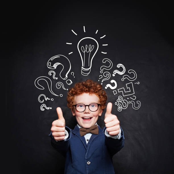 istock Child boy having fun on blackboard background with lightbulb 1198981369