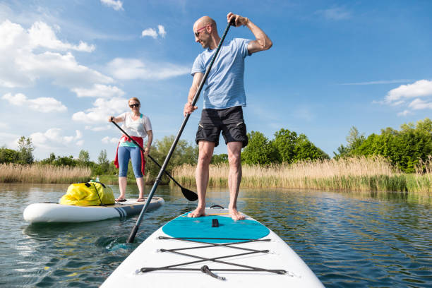 Couple on stand up paddle board on the lake, SUP Couple on stand up paddle board on the lake, SUP paddleboard photos stock pictures, royalty-free photos & images