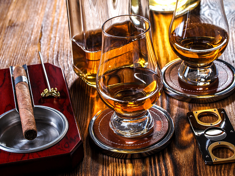 Whisky in Glencairn glasses and a cigar in an ashtray