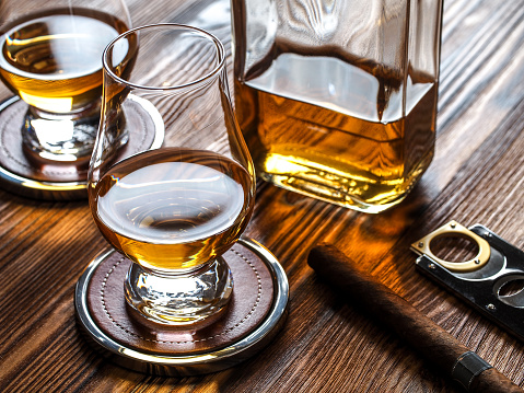 Whisky in Glencairn glasses and a cigar in an ashtray