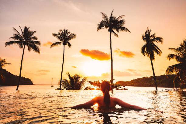 istock Asian woman relax in pool on beach 1198989779