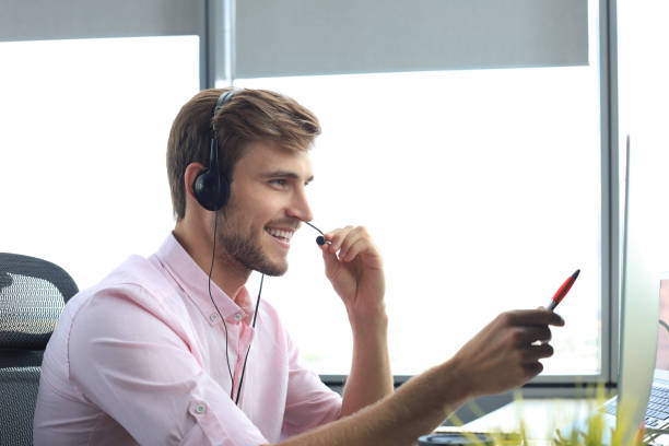 istock Happy young male customer support executive working in office. 1198990674