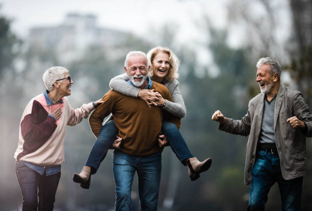 istock Playful mature couples having fun during autumn day in nature. 1198990910
