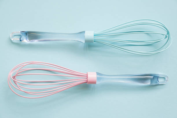 istock Pink and blue silicone whisks  with clear handle  on blue background, tp vuew 1198990994