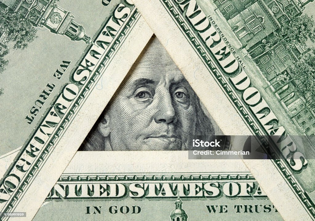 Triangle made of $100 bills with Benjamin Franklin inside Triangle made of $100 banknotes with Benjamin Franklin portrait inside. Conspiracy Stock Photo