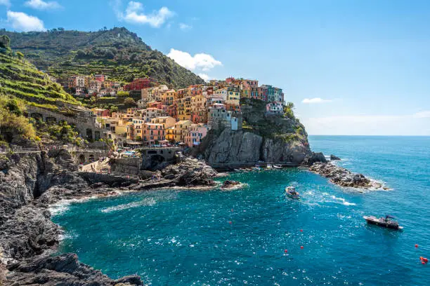 Photo of Manarola village viewed from the harbor facing to the sunlight. Cinque Terre National parc  in the Northwest of Italy.