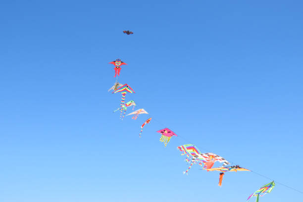 istock Colourful kites flying in the blue sky, beach fun for children 1198997295