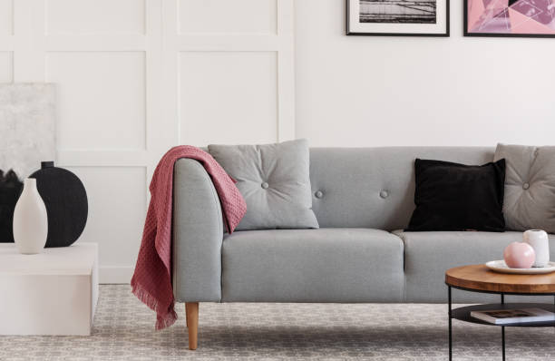 istock Comfortable grey sofa with pillows in elegant living room with scandinavian design 1198997924