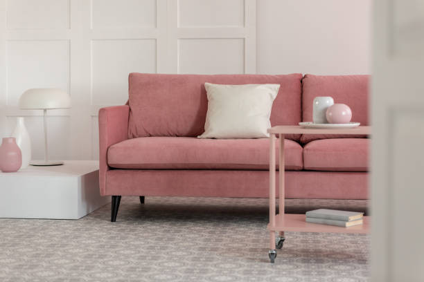 istock Stylish coffee table with kinck knacks in front of elegant couch with pillows 1198997925