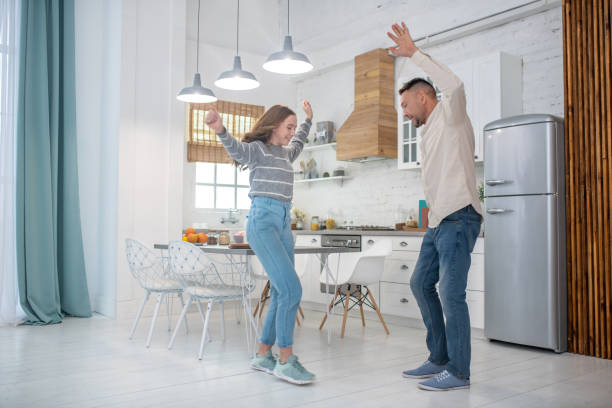 istock Smiling father with daughter dancing in the kitchen. 1199002528