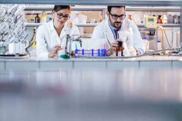 istock Young scientists analyzing chemical substances in test tubes while working on research. 1199002673