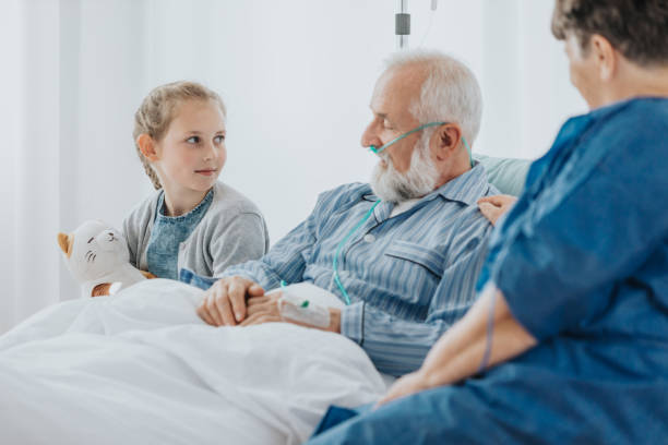 Talking with granddaughter Older sick man with oxygen pipe talking to his young granddaughter in a hospital medical oxygen stock pictures, royalty-free photos & images