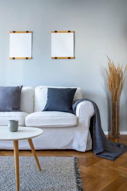 istock Grey pillows and blanket on white sofa in small living room 1199005329
