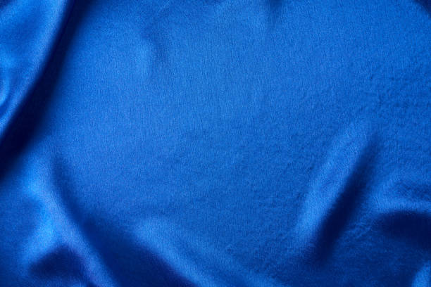 istock Blue silk background with a folds.  Abstract texture of rippled satin surface 1199008463
